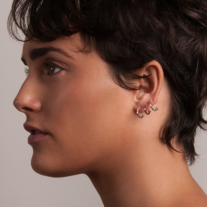 Shop delicate everyday jewelry from Haley Lebeuf. Best of ATX winner from Austin Monthly Magazine. The model is wearing three of the Fate Tiny Hoops from the Sequence Collection in both sterling silver and 14k gold-fill. Shop easy to wear pieces here.